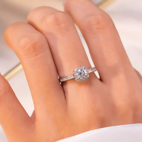 Two carat cushion halo moissanite ring worn on a finger