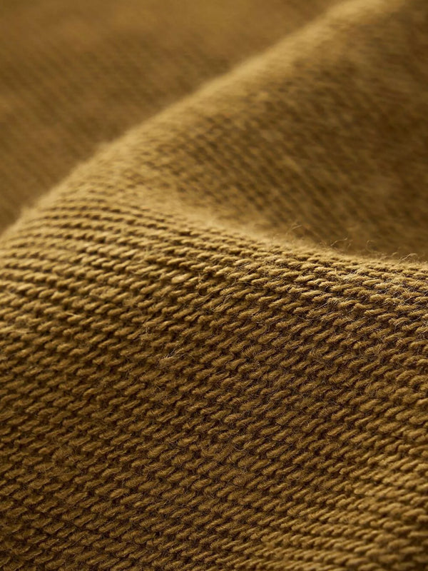 Close-up of mustard hoodie fabric showing looped knit texture