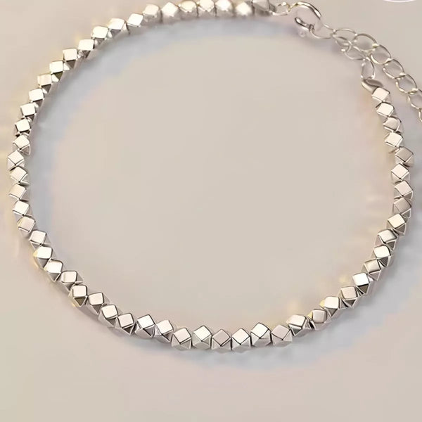 Faceted geometric links arranged in a silver bracelet with extension chain