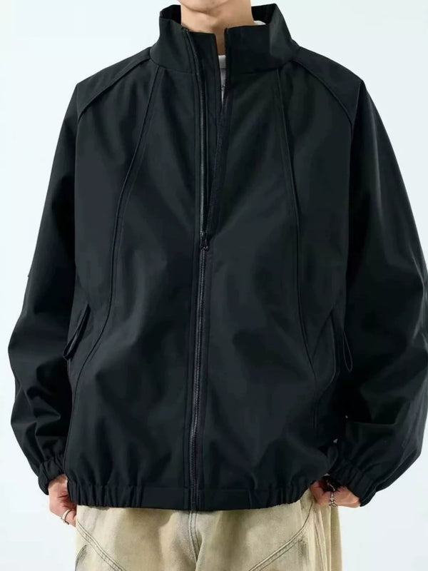 Model wearing black zip-up raglan jacket with stand collar, zipped front view