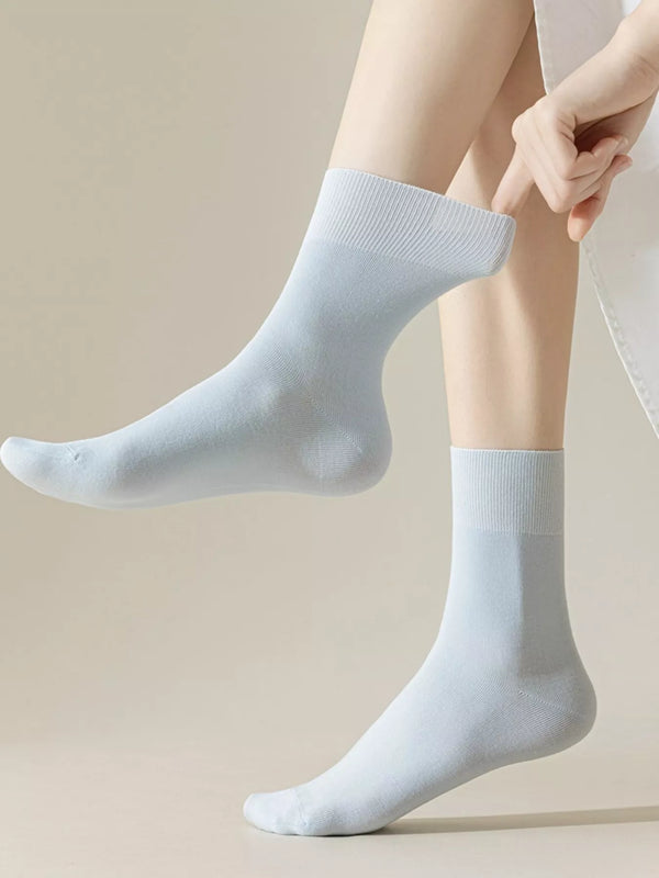 Light blue crew socks worn on feet, showing ribbed cuffs