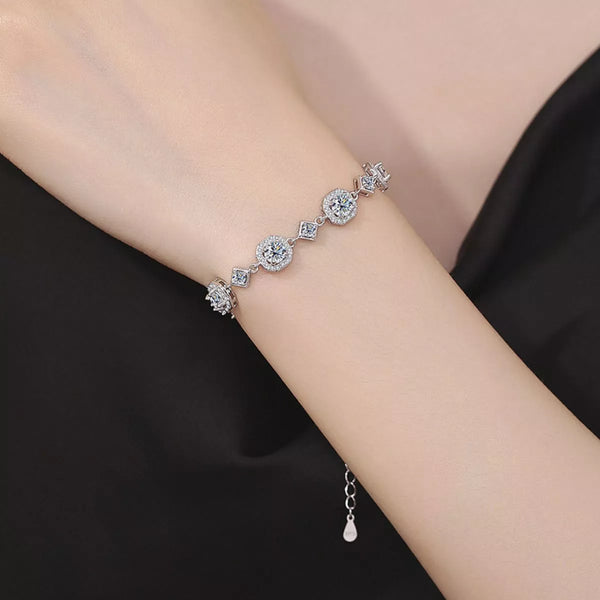 Silver-tone bracelet with round and square sparkling links worn on a wrist