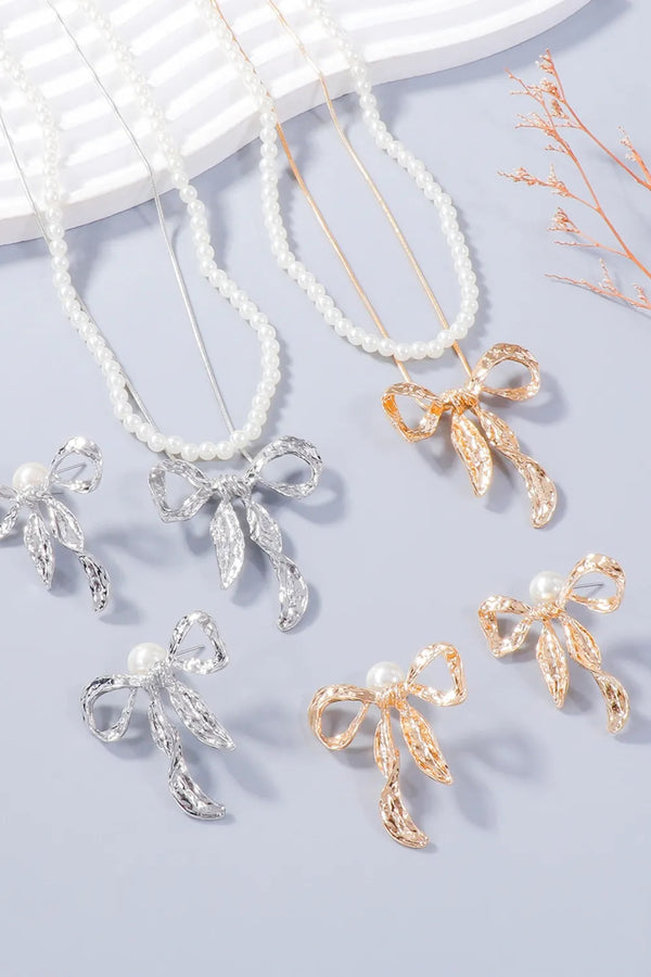 White beaded necklaces and matching bow earrings in silver-tone and gold-tone finishes