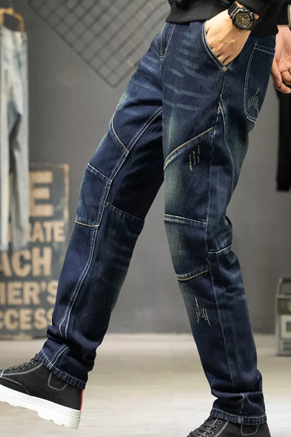 Angled view of dark blue straight-leg jeans showing faded thighs and stitched knee panels