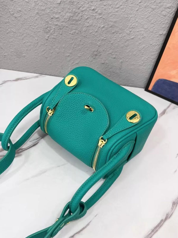 Teal crossbody bag viewed from above, showing front flap and gold-tone fittings