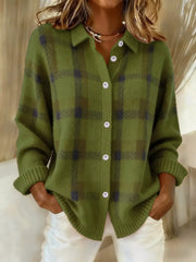 Olive green plaid cardigan with a collar and pale front buttons, worn with white trousers.