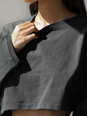 Close-up of charcoal sweatshirt neckline, sleeve cuff and cropped hem
