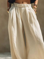 Front view of cream elastic-waist wide-leg pants with hands in pockets