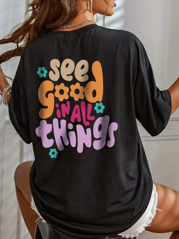 Back view of a black oversized T-shirt with a colorful See Good in All Things graphic