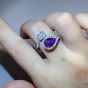 Purple teardrop bypass ring with halo worn on a hand