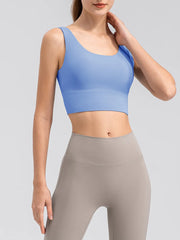 Model wearing the blue tank showing its scoop front and wide straps