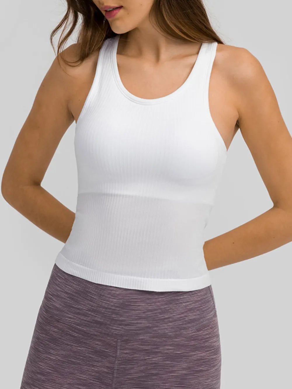 Model wearing white ribbed racerback tank with heathered leggings