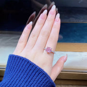 Close-up of pink square center stone on finger