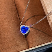 Angled close-up of blue heart-shaped zircon necklace on jewelry-box lining