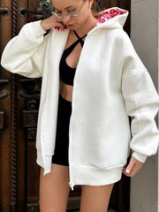 Front view of oversized white zip hoodie worn open, showing red lip-print hood lining