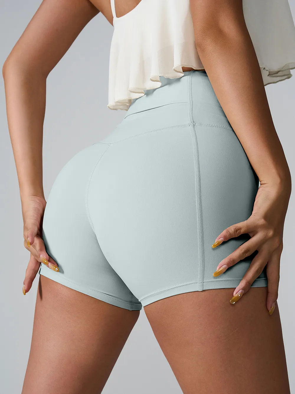 Rear view of pale blue fitted shorts with a wide high-rise waistband.
