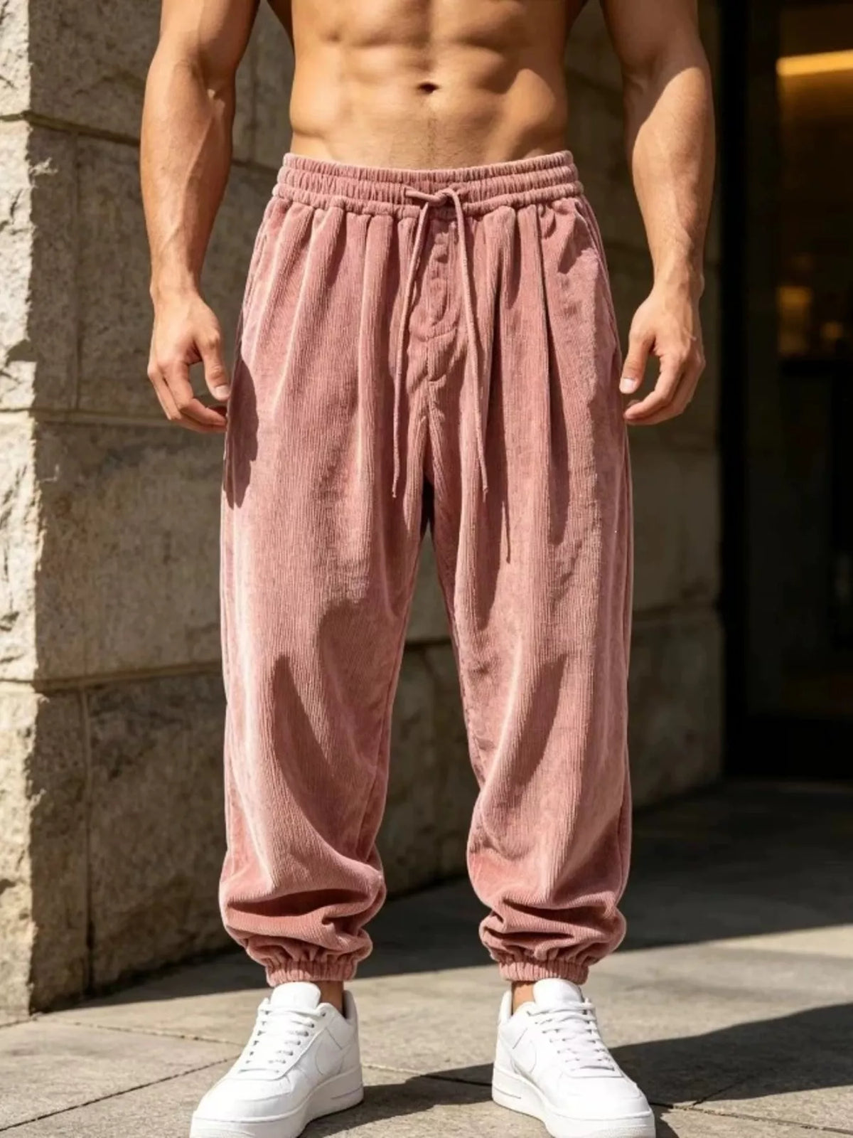 Model wearing dusty pink corduroy drawstring joggers with gathered hems