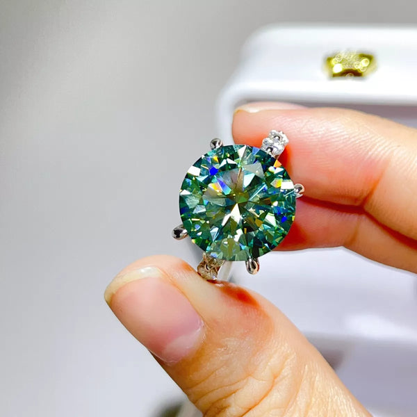 Close-up of green-blue centre stone ring held between fingers