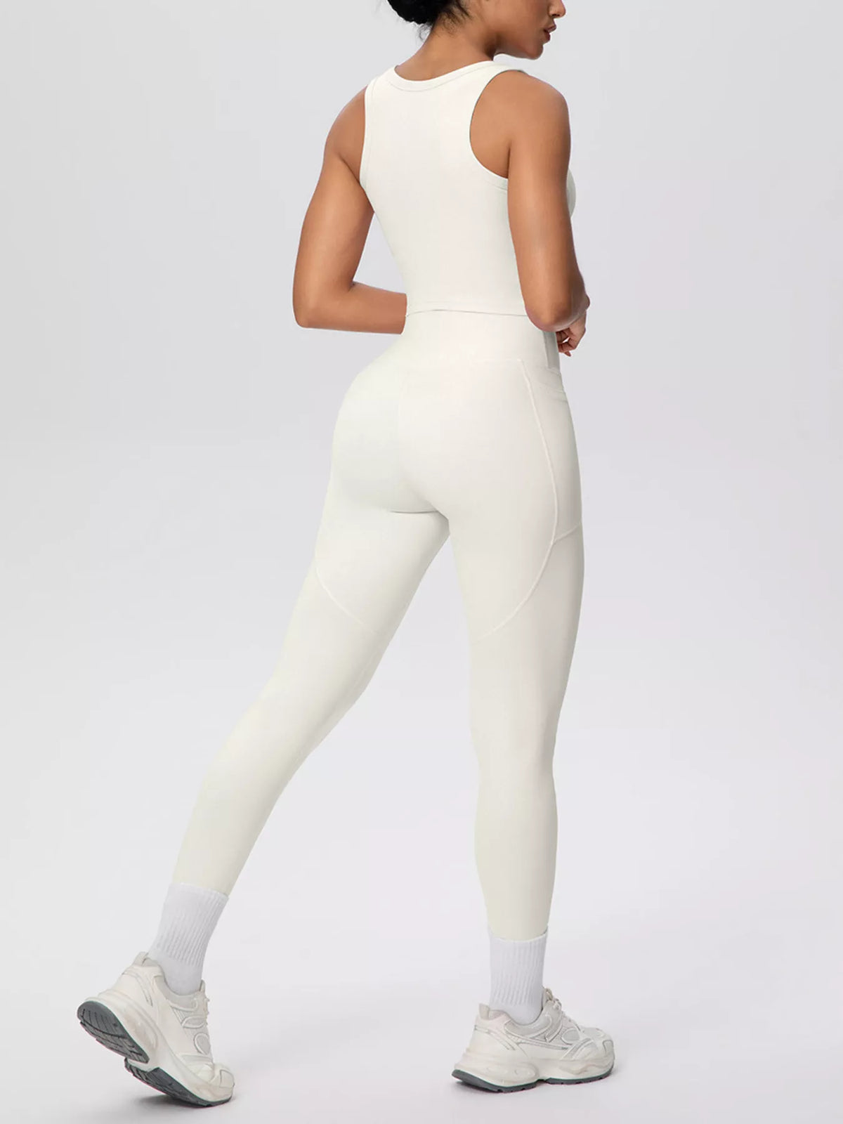 White tank and leggings shown from behind in a walking pose