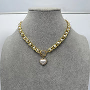 Chunky pearl and heart pendant necklace displayed on a grey bust