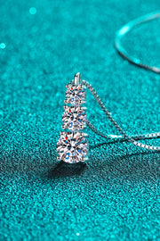 Side view of three clear stones set vertically on a silver necklace