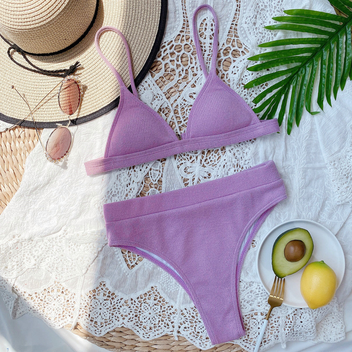 Lavender ribbed bikini set laid flat with sun hat and accessories