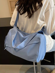 Close-up of blue shoulder duffel bag showing its curved zip pocket and carry handles