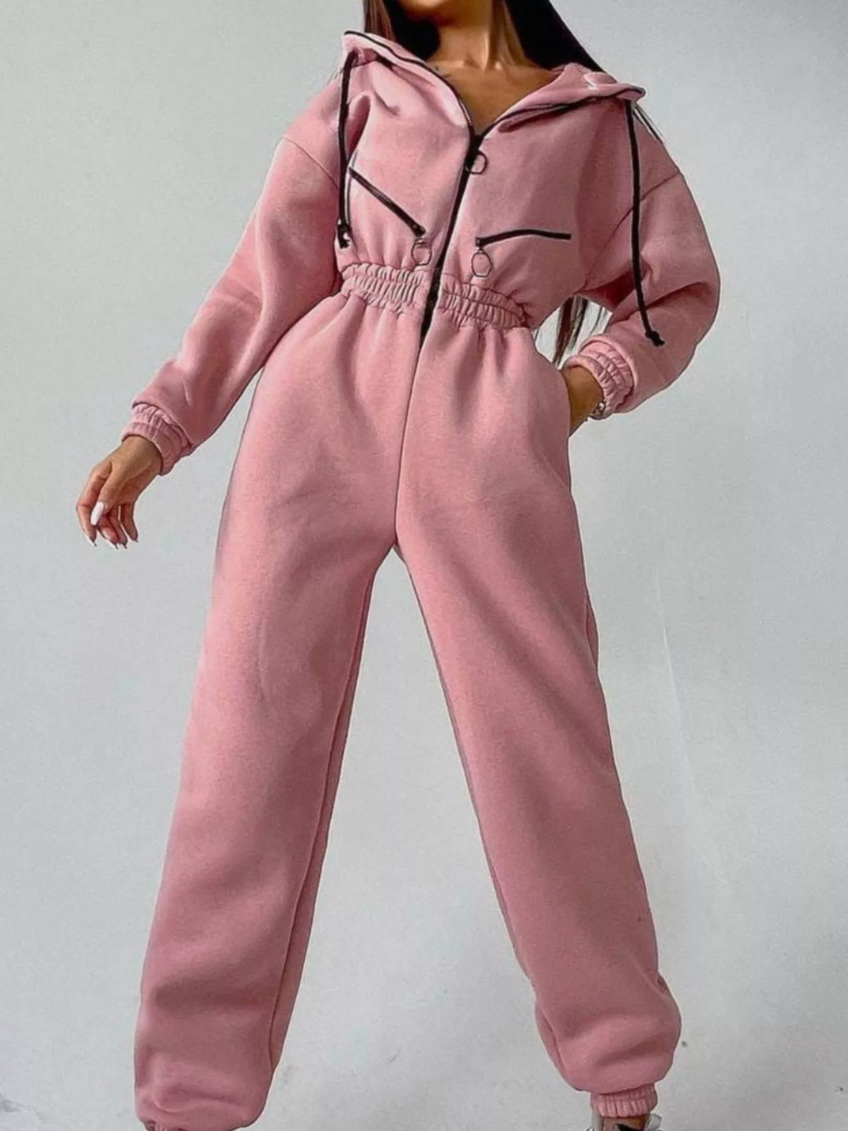 Women's rose pink hooded jumpsuit, model angled front pose with hand at waist