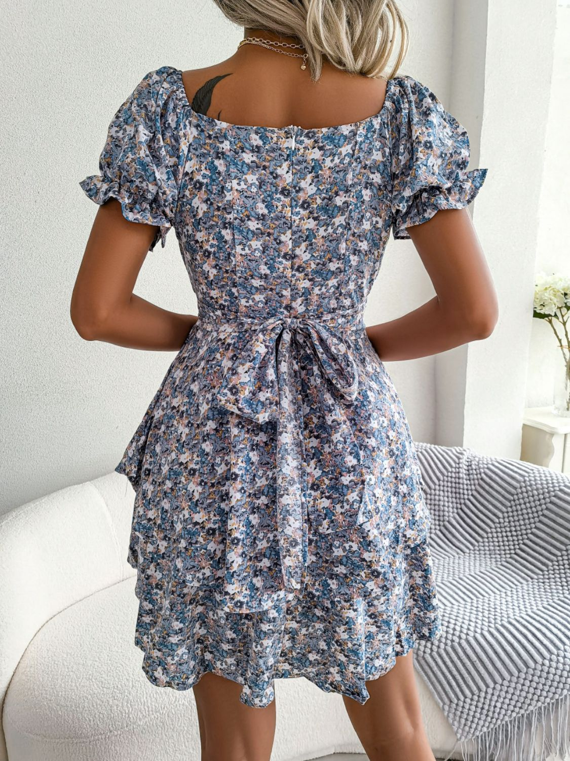 Back view of blue floral dress showing its fitted bodice and flared mini skirt