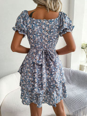 Back view of blue floral dress showing its fitted bodice and flared mini skirt