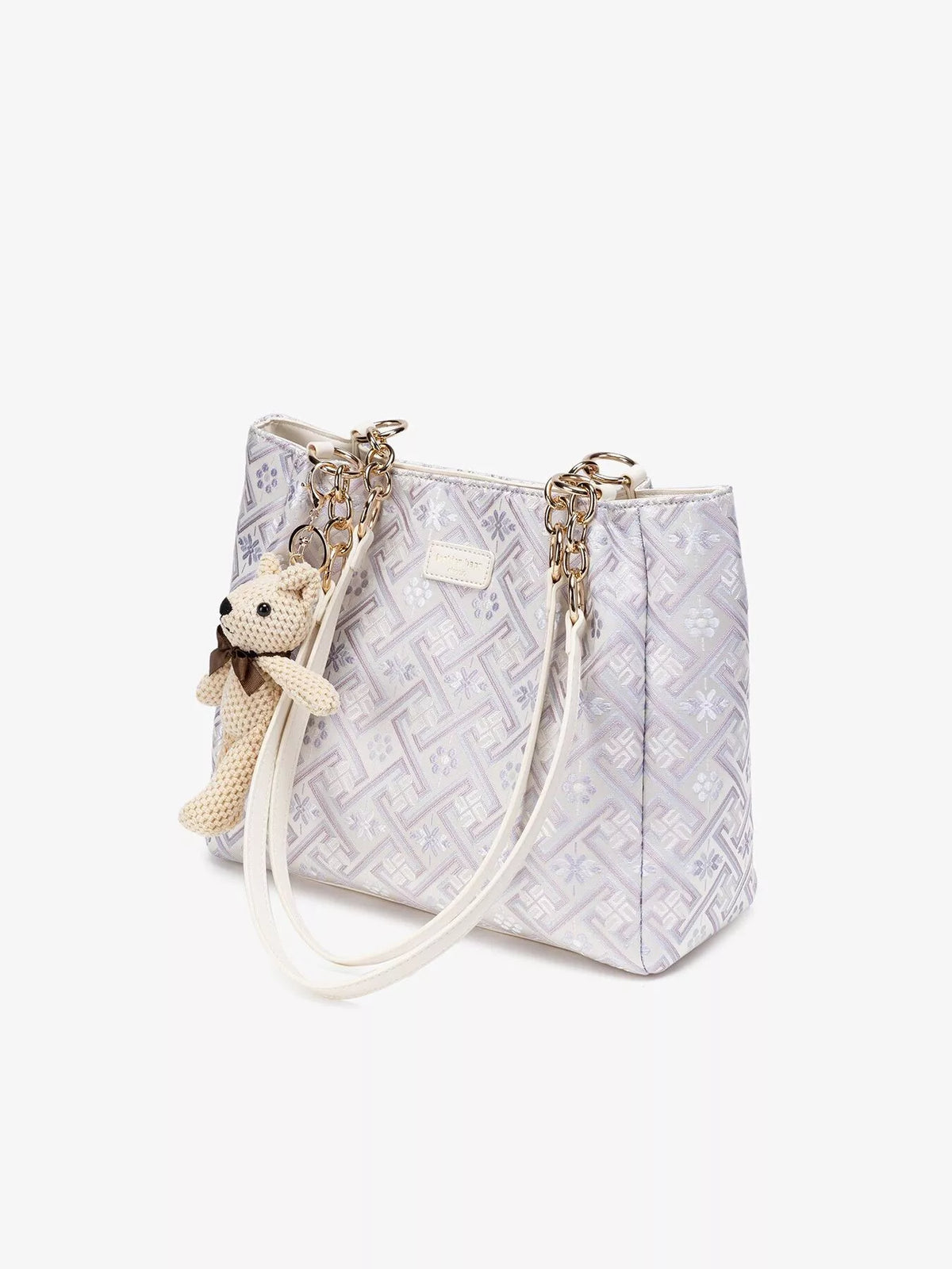 Angled view of geometric jacquard tote and chain handle attachments