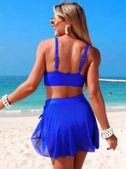 Front view of blue three-piece swim set on beach