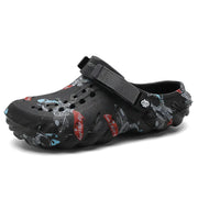 Black graffiti-print clog with rounded toe and textured sole, product view
