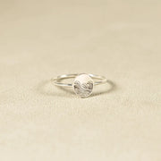 Round engraved face sterling silver ring on light fabric