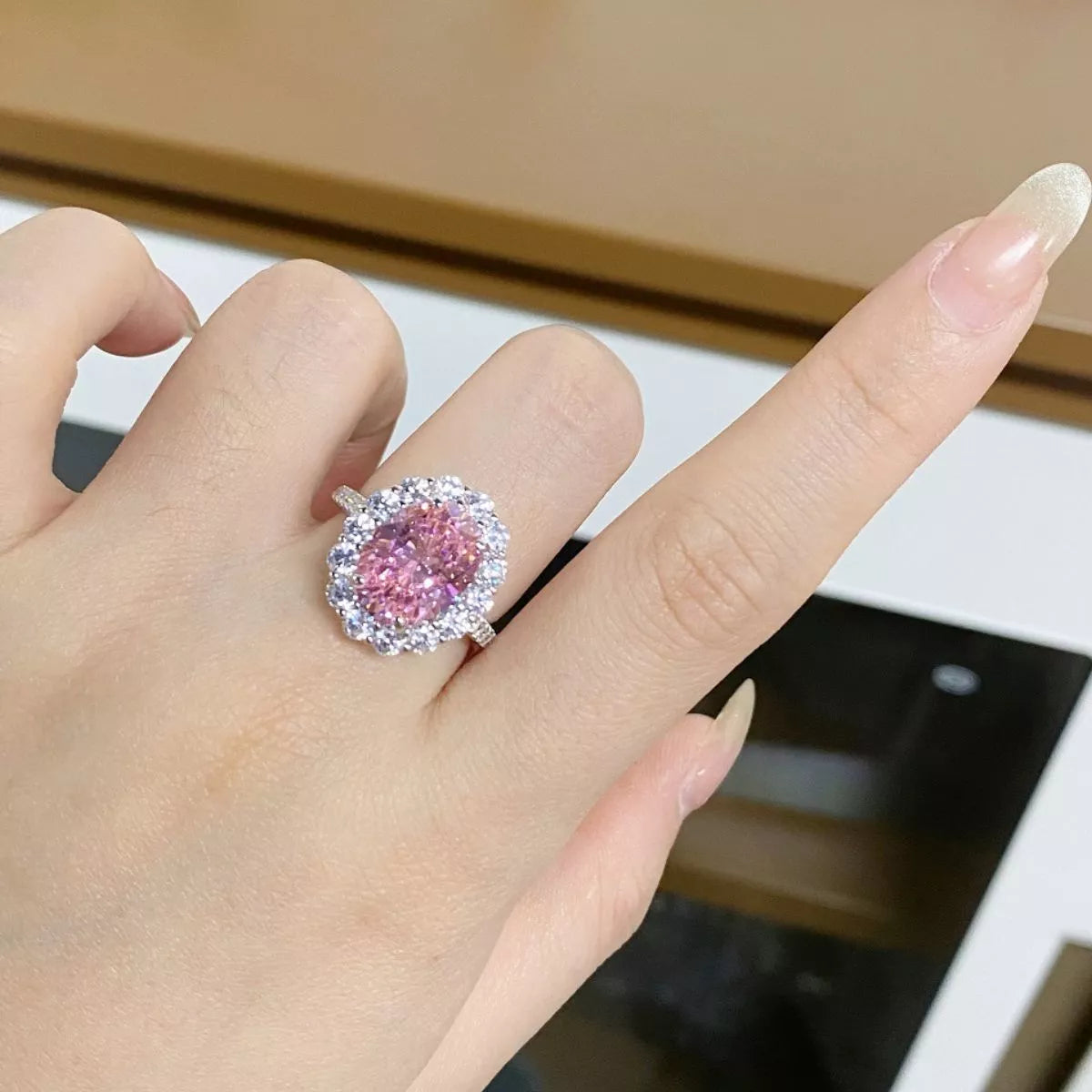 Blush pink oval zircon ring worn on a hand.