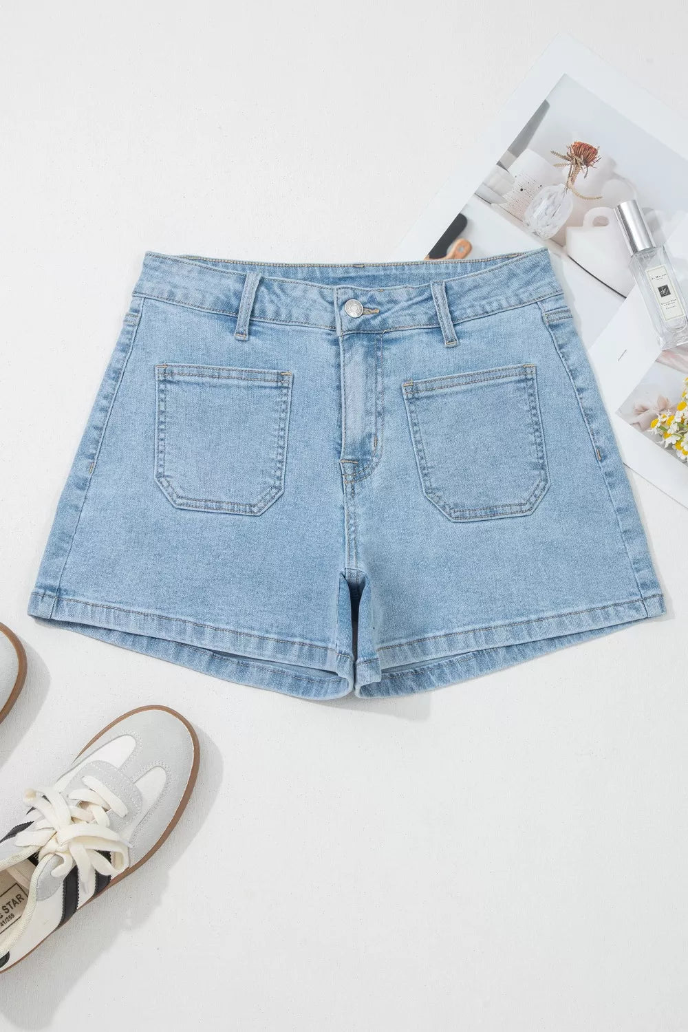 Back view of light-blue denim shorts with patch pockets laid flat