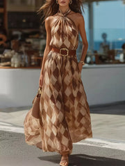 Model wearing a brown diamond-print halter maxi dress with a wide belt, walking outdoors.