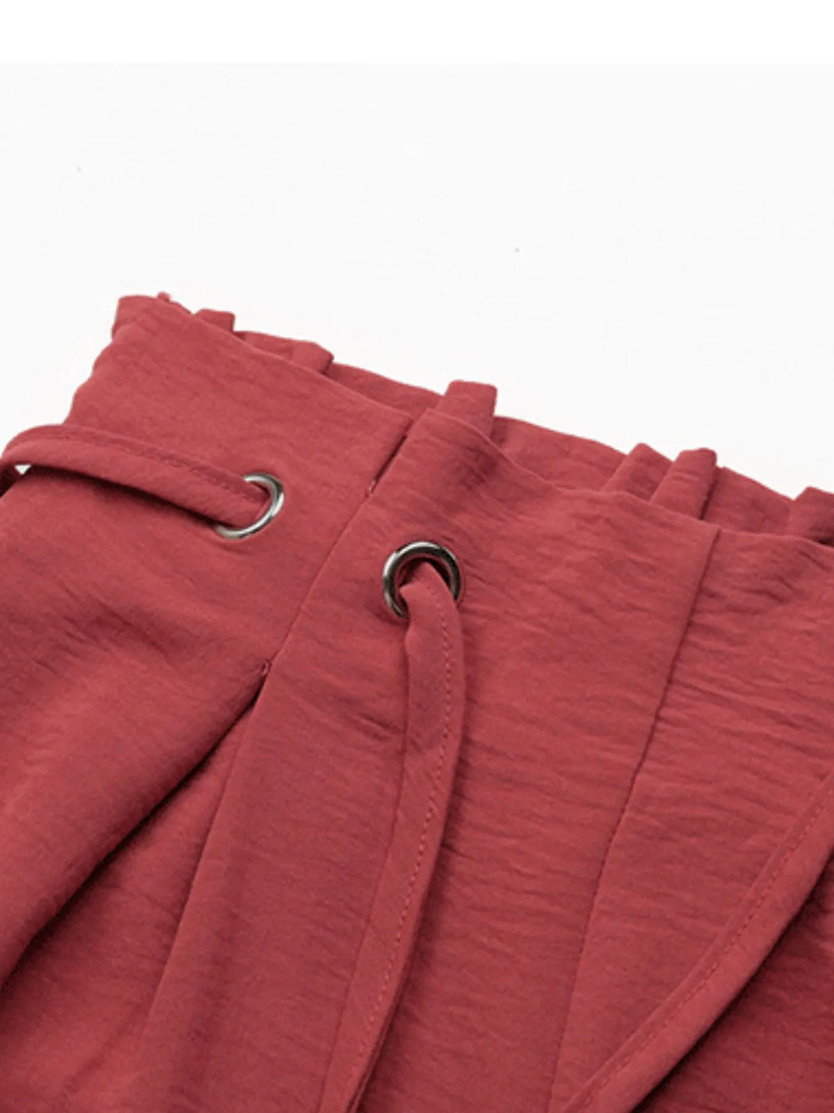 Close-up of rose shorts' gathered waistband and tie eyelets