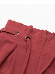 Close-up of rose shorts' gathered waistband and tie eyelets