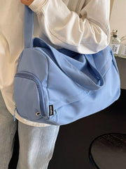 Side view of blue duffel bag showing a rounded zip compartment and two carry handles