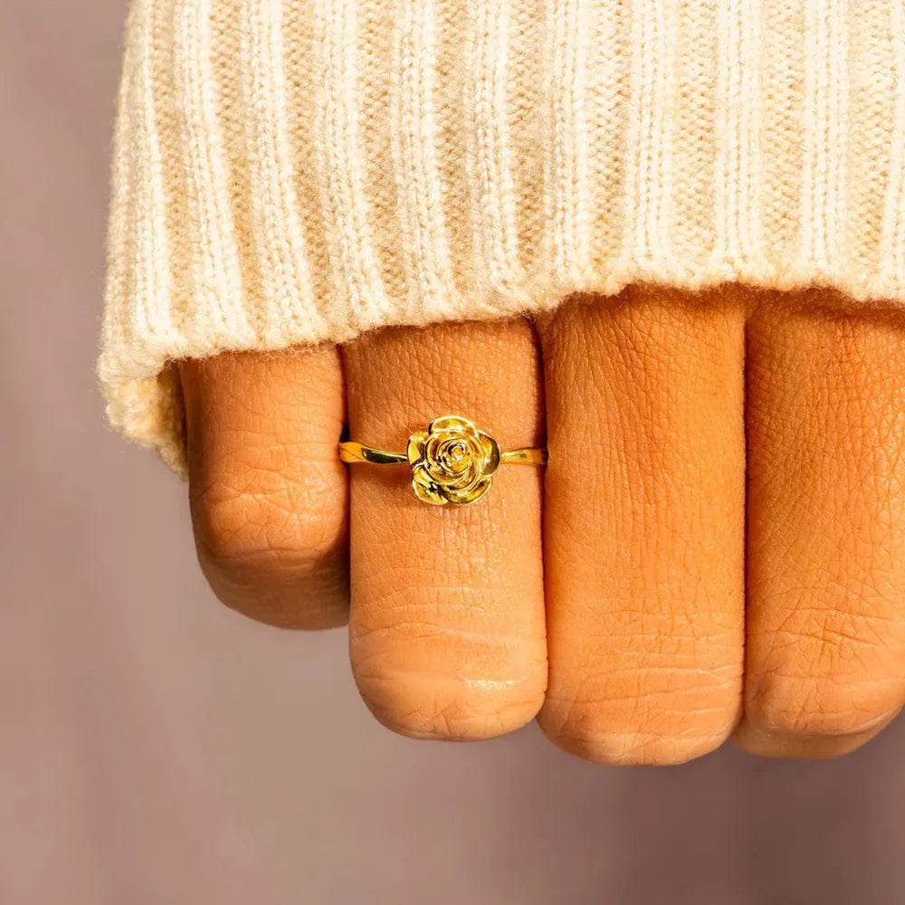 18K gold-plated rose-shaped ring worn on fingers beneath a knit cuff