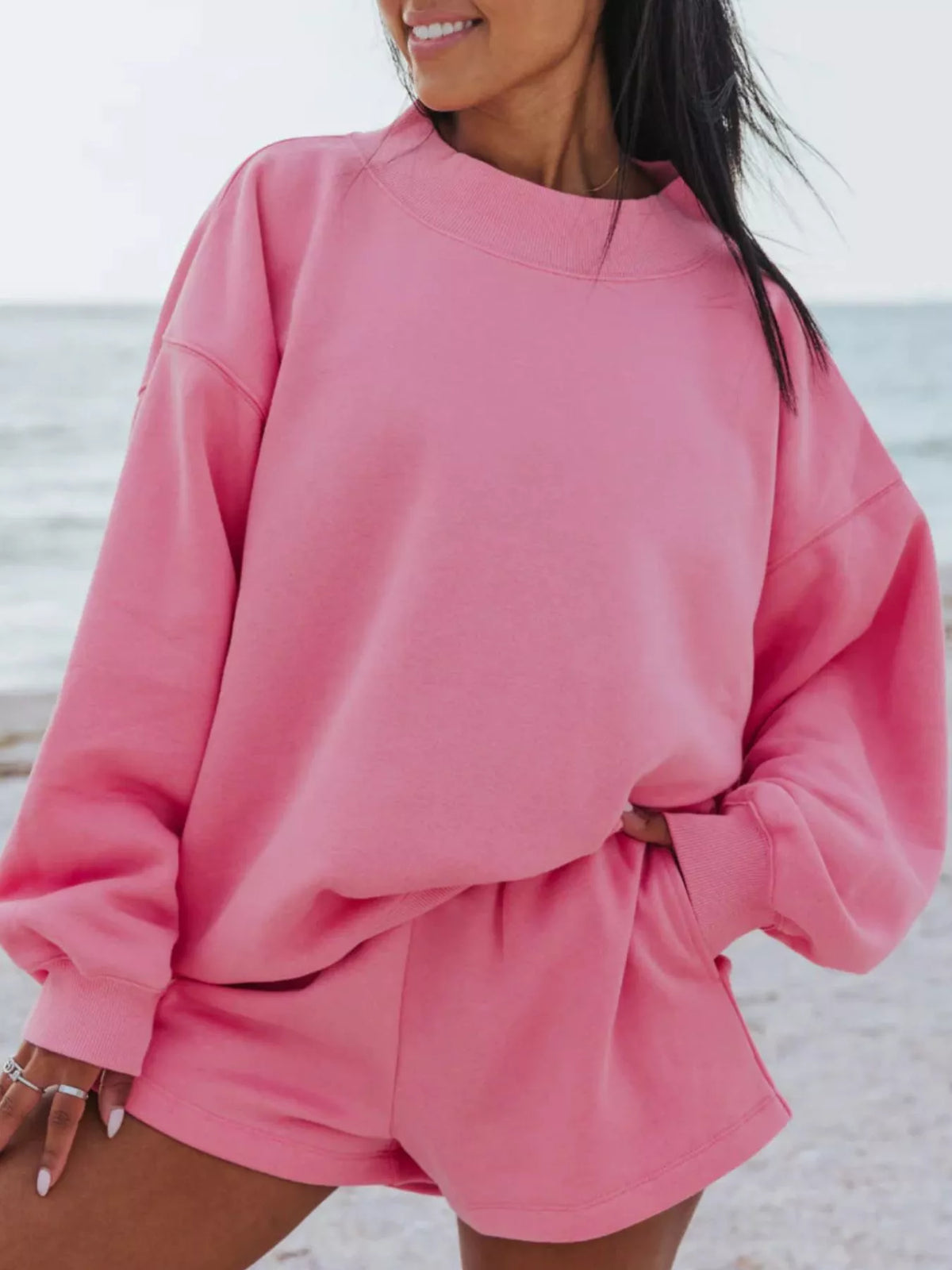 Front view of a bright pink oversized crewneck sweatshirt with matching shorts.