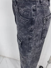 Close-up of washed cargo jeans showing side and flap pocket stitching