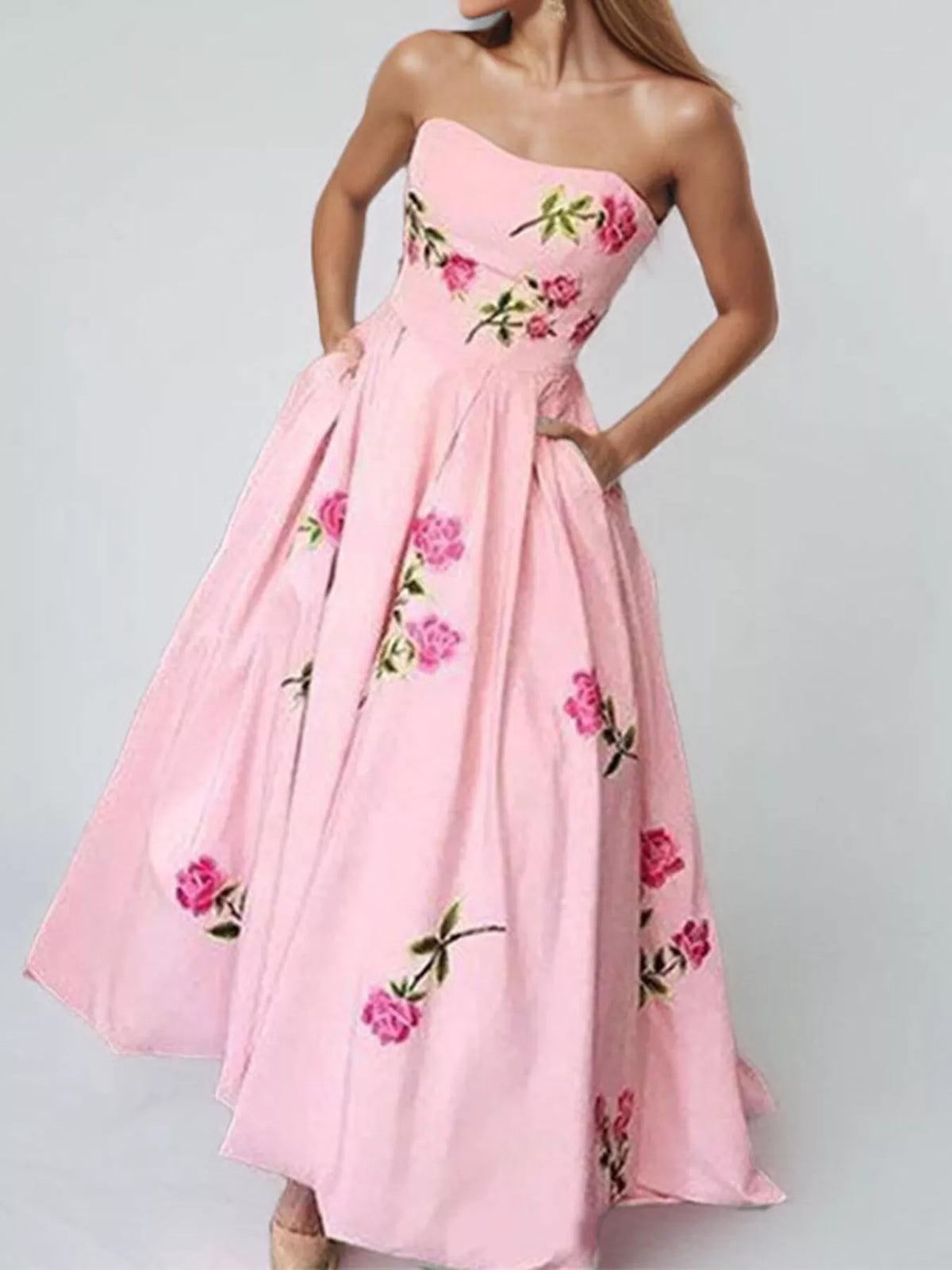 Model wearing a pink strapless floral maxi dress, full-length view.