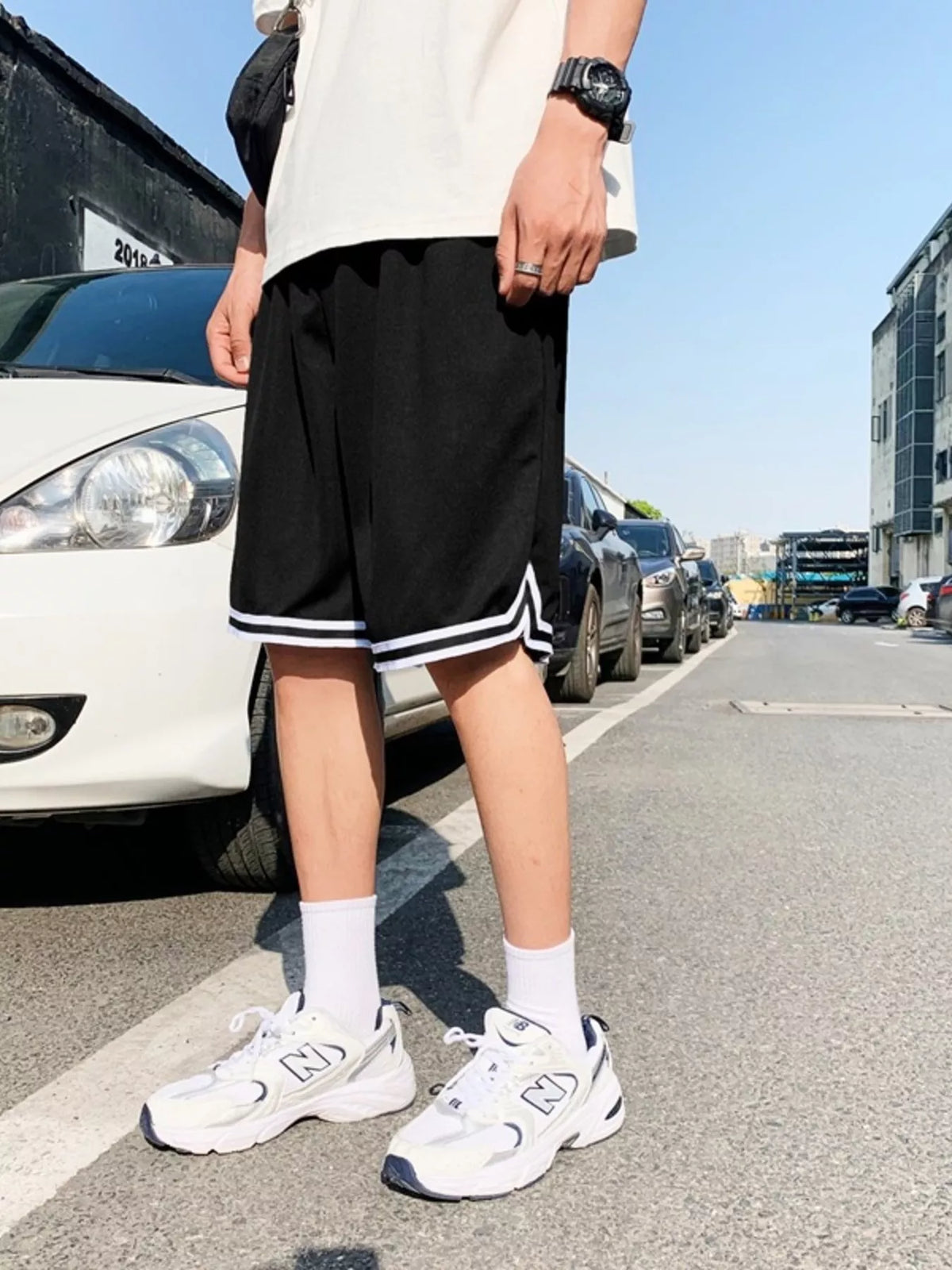 Side view of model in black shorts with white piping
