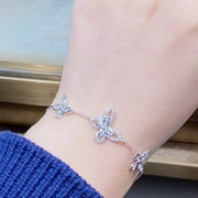 Close view of the butterfly accents on the chain bracelet worn on a wrist