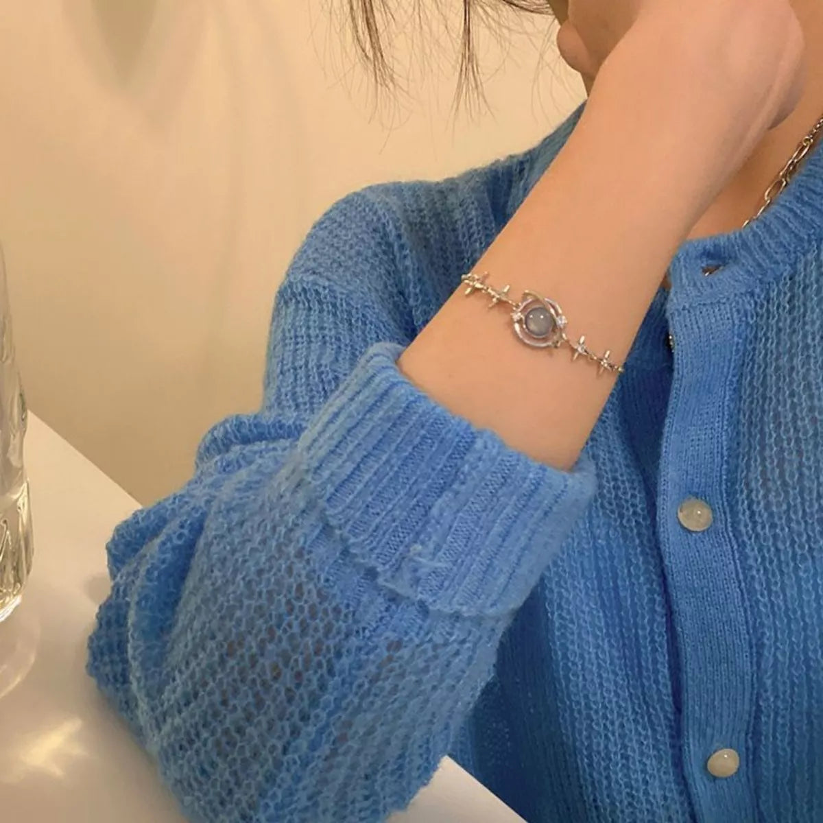 Close view of the planet bracelet worn with a blue sleeve