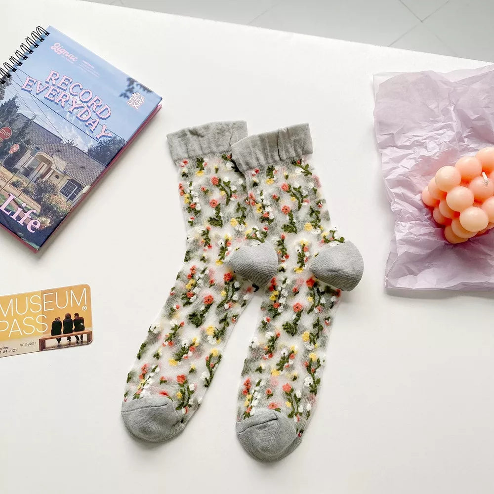 Pair of floral sheer socks with gray cuffs and toes