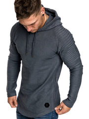 Man wearing a charcoal-gray hooded pullover with ribbed shoulder panels and drawstrings.