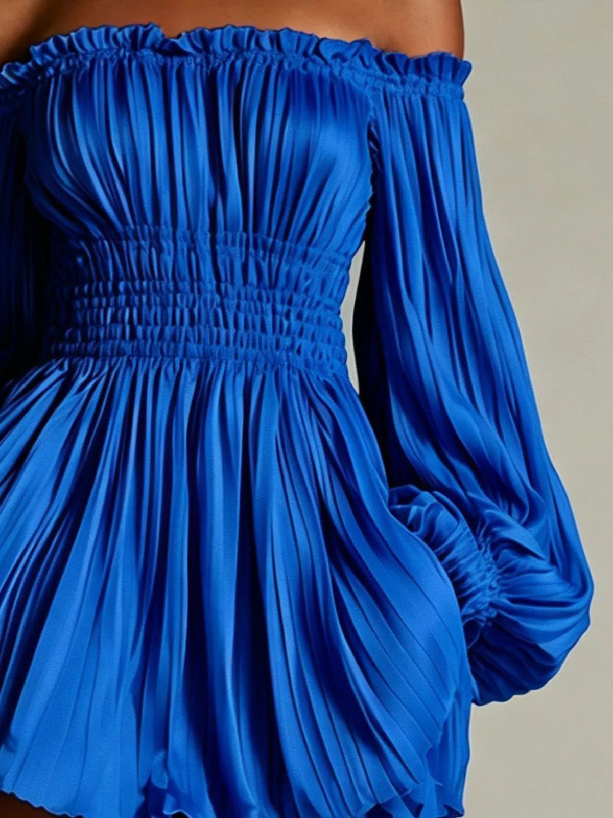 Closer view of blue dress showing pleated bodice and gathered waist